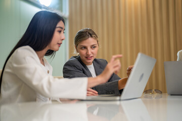 Diverse business team meeting and discussing marketing research and strategy using laptop, collaboration and communication planning, analysis, brainstorming for innovation, productivity, leadership
