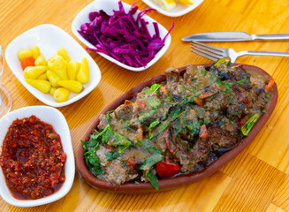 Portion of traditional Turkish dish, tirit, served on table with appetizers.
