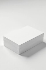Fototapeta premium A close-up shot of a stack of blank white business cards on a white paper background, business card, corporate