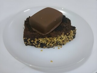 Indulge in this rich and moist chocolate cake, topped with a luscious chocolate bar. A perfect dessert for chocolate lovers!