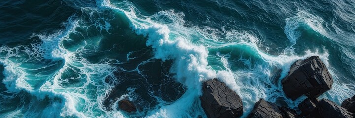 Dramatic ocean scene with powerful waves crashing against rugged rocks from above