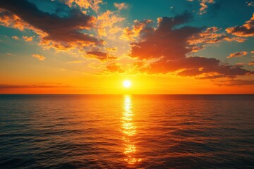 Obraz premium Stunning sunset over a calm ocean with vibrant orange and blue hues.