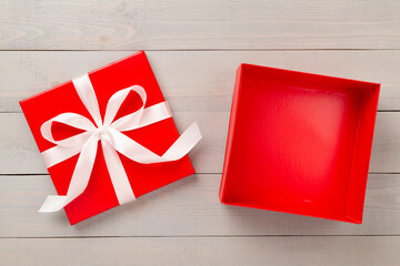 Open red gift box on wooden background, top view