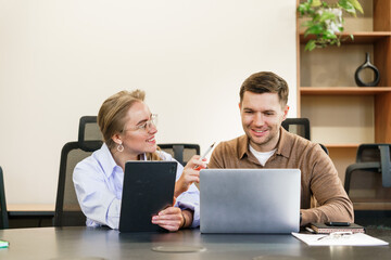 Collaborative brainstorming session in a modern office between two colleagues using digital devices