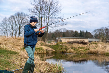 A Young Angler Lovingly Enjoys a Beautiful and Wonderful Day of Fishing by the Serene Pond