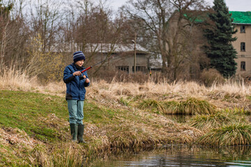 A Young Fisherman Enjoying Time by a Serene Riverbank in a Beautiful Spring Landscape