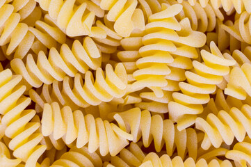 Raw fusilli pasta creating appealing culinary background