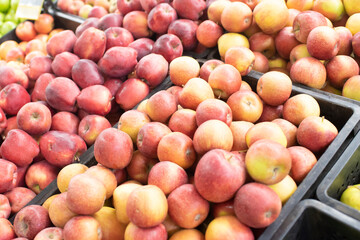 red apples in plastic boxes at the grocery store