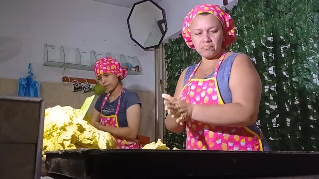 Two colombian women preparing Achira cakes in a kitchen in Yaguar&aacute; - Huila - Colombia. Colombian food and job concept