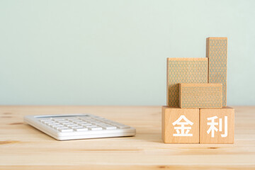金利と書かれたブロック、不動産の模型、電卓