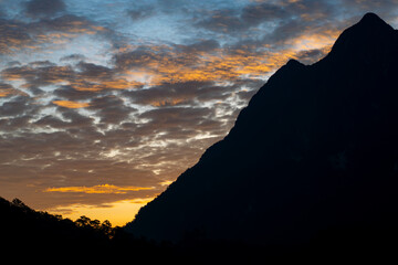 Mountain range is silhouetted against a beautiful sunset sky