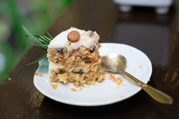 Slice of carrot cake with a spoon on a white plate