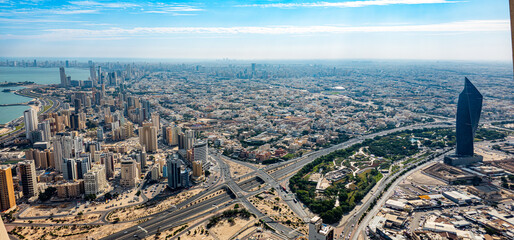 Aerial View of Kuwait City Featuring Tijaria Tower, Coastal Skyline, Highways, and Urban Landscape on a Clear Day – Kuwait
