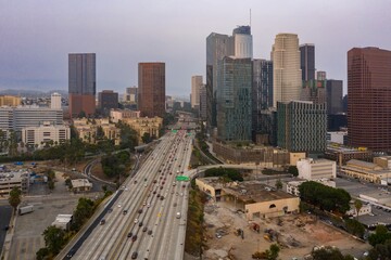 Obraz premium Los Angeles, USA: Aerial view of the 110 freeway with heavy traffic flowing into downtown. Skyscrapers rise in the background, showcasing the city's urban landscape.