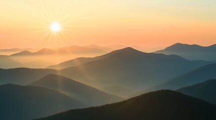 Obraz premium Aerial view of misty mountains at sunrise with golden light casting over rolling peaks, creating a breathtaking and tranquil natural landscape.