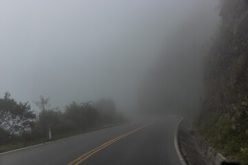 Misty view of a road descending from Abra Malaga pass to Lucumayo river valley, Peru