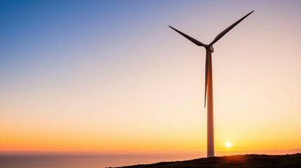 Serene silhouette of a wind turbine at sunset against a beautiful coastal scene creating a peaceful mood and atmosphere