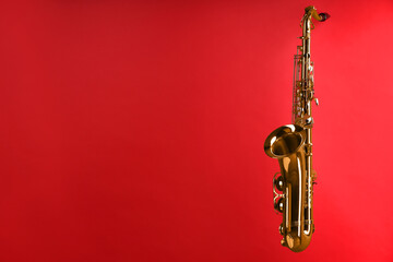 Jazz. One beautiful saxophone on red background, space for text