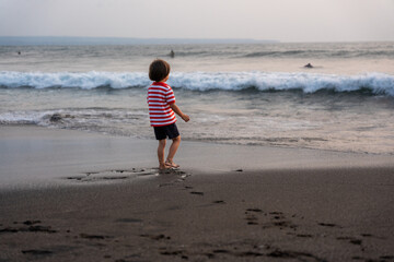 ビーチを歩く男の子の後ろ姿