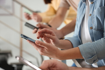 Obraz premium Internet addiction. Group of people with smartphones on stairs indoors, closeup