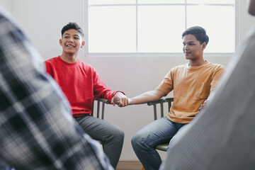 Obraz premium Portrait Of Smiling Two Young Asian Man Holding Hands Each Other For Psychological Support