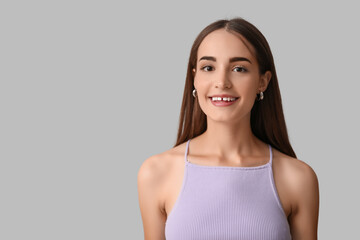 Obraz premium Young woman with diastema smiling on light background, closeup