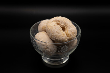 A glass bowl filled with cinnamon sugar cake donuts showcases their golden-brown, sugary coating. The soft, fluffy texture and warm, comforting aroma make these treats irresistible.