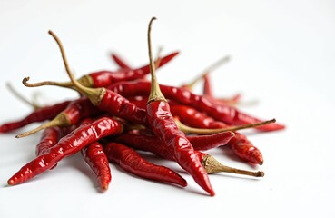 Pile of dry organic Kashmiri red chili peppers on white background. Well known for dark red color. Food ingredient for Indian Gujarati cuisine recipes. Spice for tasty meals.