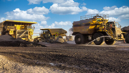 Obraz premium truck watercart tank mining equipment and at a diamond mine ,outdoors sunset with blue sky late in the day