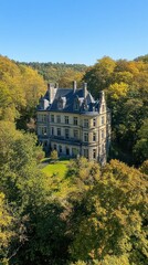 Obraz premium Majestic chateau nestled in a valley, surrounded by autumn foliage