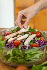 Tender, seasoned grilled chicken strips perfectly placed over a vibrant salad of lettuce, cherry tomatoes, and red cabbage, creating a delicious and healthy meal.

