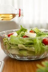 A refreshing post-workout salad with tomato, lettuce, and hard-boiled egg, being drizzled with olive oil, perfect for a nutritious and delicious recovery meal.

