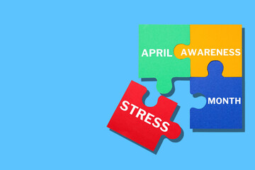 Stress month, puzzles of different colors with the words April Awareness Stress Month on a blue background, space for text, top view
