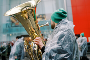 Canada, Toronto - 16 march 2025: Saint Patrick Day Parade. Band Member Playing Tuba at Outdoor Event Despite Rain