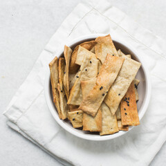 Overhead view of homemade crackers, top view of freshly baked black sesame cracker biscuits, process of making crackers