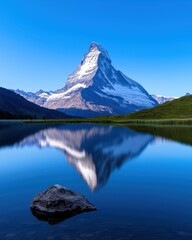 Stunning mountain reflection in a serene lake under a clear blue sky.
