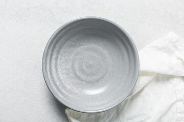 Top view of grey ceramic plates on a marble table, handmade grey ceramic plate on a white background