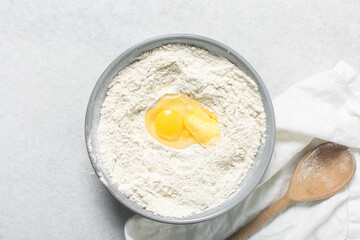 Overhead view of doughnut dough being mixed in a grey mixing bowl, top view of doughnut dough on a white countertop, process of making doughnut