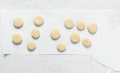 Overhead view of doughnut dough on a white countertop, top view of doughnut dough on a white background, process of making doughnut