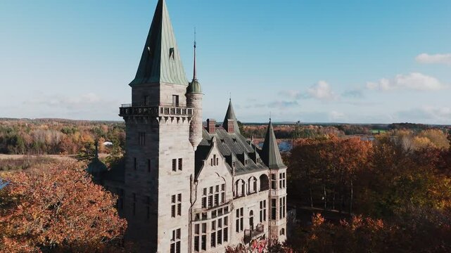 Tracking shot towards Teleborg Castle in V&auml;xjo, Sweden, Fall, Orange and Yellow Leafs, Flying past the castle, revealing the forest