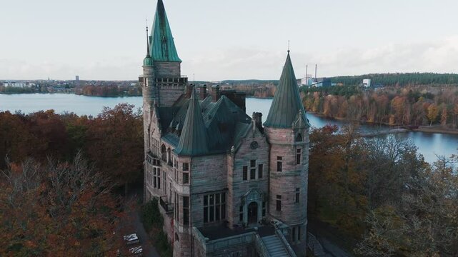 Tracking shot towards Teleborg Castle in V&auml;xjo, Sweden, Fall, Orange and Yellow Leafs, Drone Closing in
