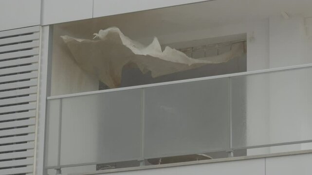 STRONG WIND MOVES PLASTIC COVERING A BALCONY UNDER CONSTRUCTION