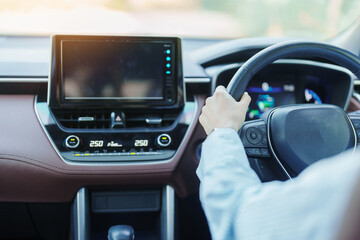 Obraz premium Businesswoman driver driving a car on the road, hand controlling steering wheel in electric modern automobile. Journey, trip and safety Transportation concepts