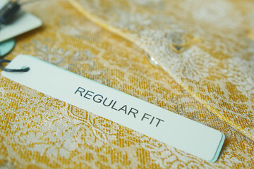 Label indicating regular fit on a lace garment displayed for sale