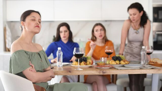 Friends quarrel at a party. Upset woman listens to screams and indignation of her girlfriends. High quality 4k footage