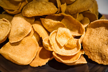 Close-up of a pile of crispy, golden brown chips, showcasing texture and color, emphasizing snack appeal
