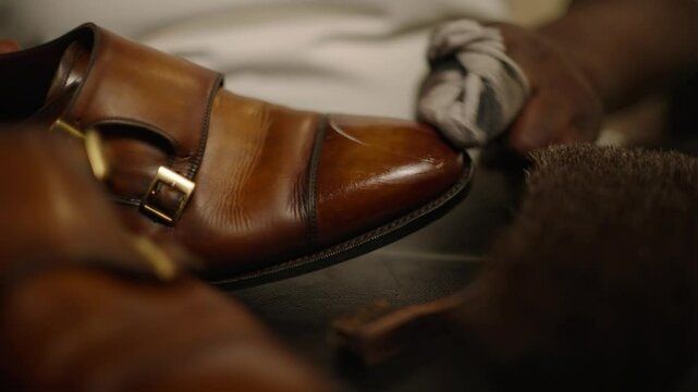 An expert shoemaker buffing and polishing a shoe to a like-new shine