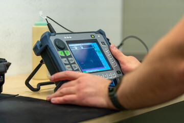 Industrial NDT Inspector Setting Up Ultrasonic Testing Equipment for Quality Control. Technician...