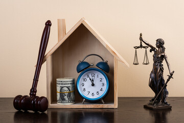 Symbolic wooden house, alarm clock, judge's gavel and US$1 bills
