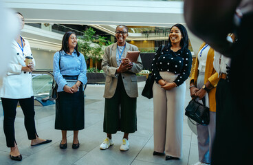 Professional colleagues greet and interact during a tour of their new workplace